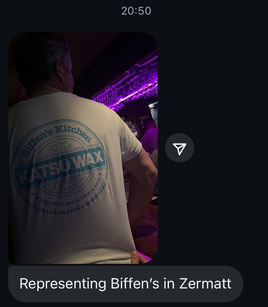 Person wearing a white t-shirt with 'Biffen's Kitchen Katsu Wax' logo at a nightlife event.